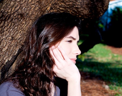 profile of young woman with head resting on hand