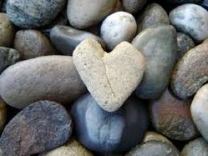 Multicolored polished and rough stones with heart-shaped stone on top.